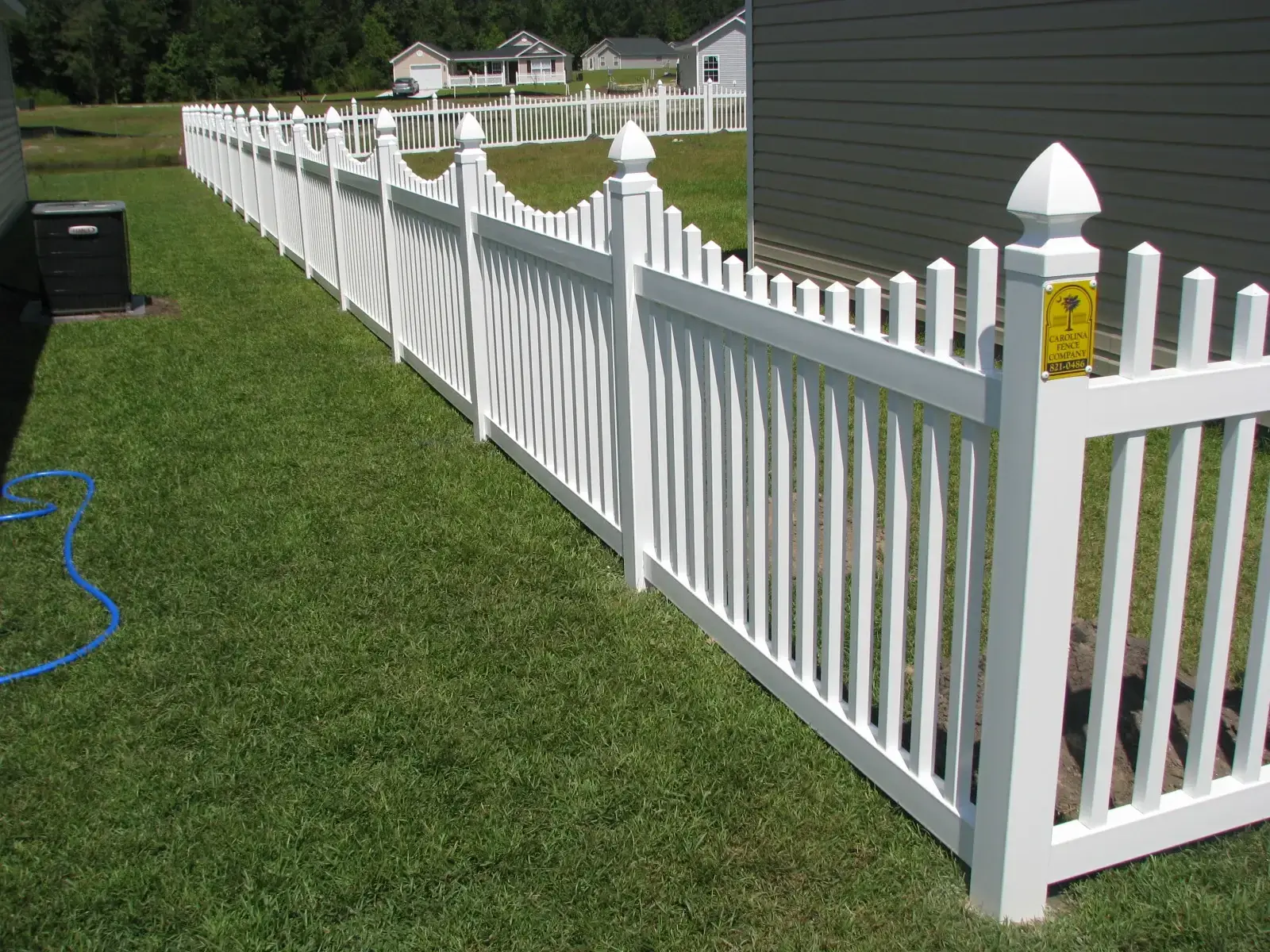 Vinyl picket fence with carolina fence company branding in charleston sc